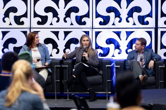 Two women and a man speaking at a conference panel 