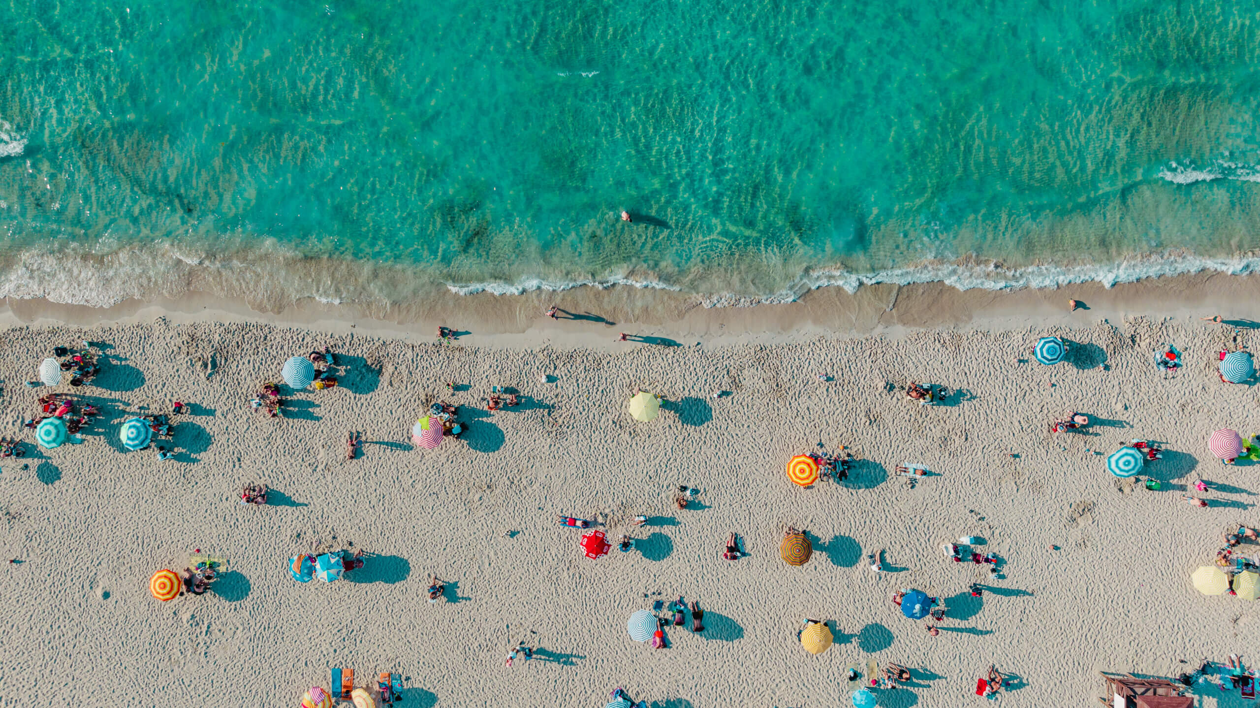 Overhead shot of colorful umbrellas at a beach