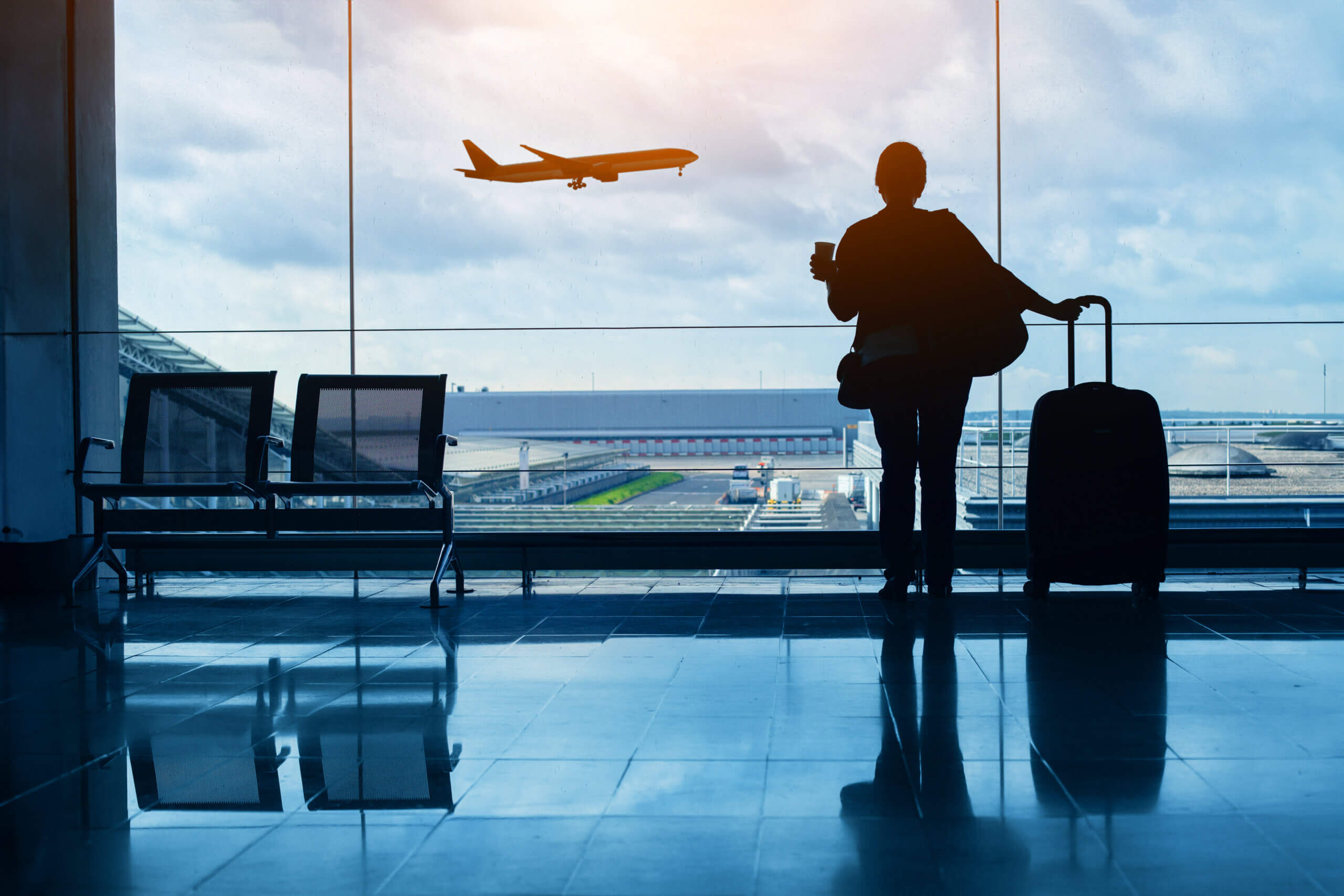 travel by plane, woman passenger waiting in airport, silhouette of passenger in airport watching aircraft taking off, travel trends 2025