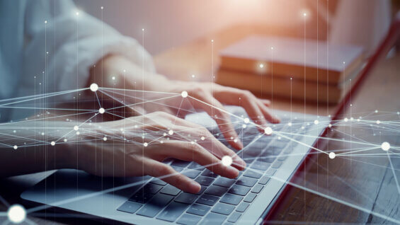 Person typing on a laptop with digital network connections overlaid, representing search and digital connectivity.