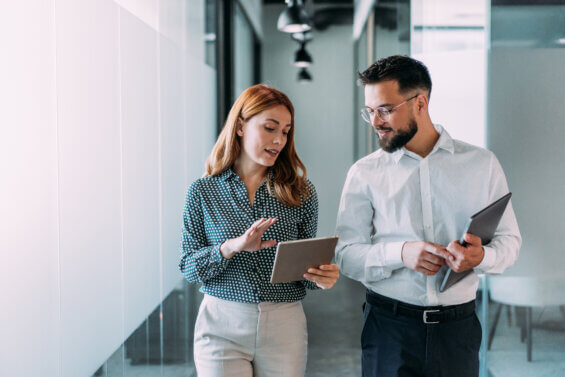 Two people looking at an iPad in an office