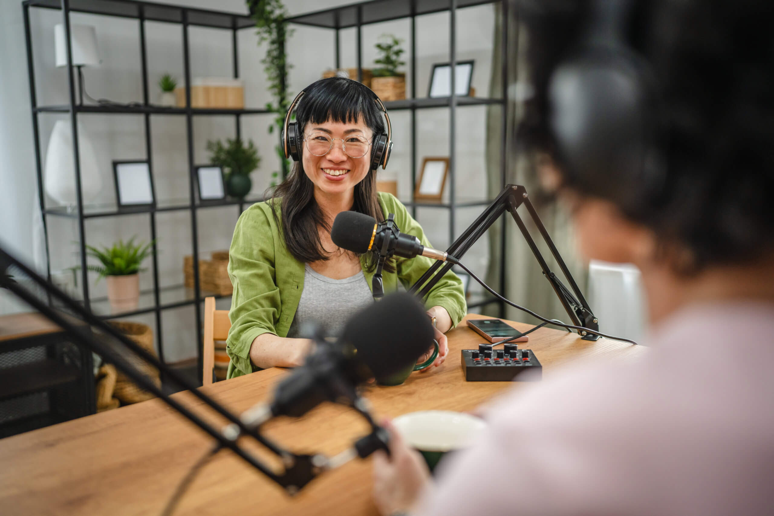woman in the podcast studio talk and record, focus on a japanese woman talk into a mic