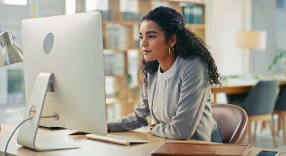 Woman in an office looking at a desktop computer screen